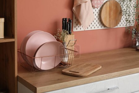 Téléchargez les photos : Comptoir de cuisine en bois avec porte-assiettes, planches à découper et ustensiles - en image libre de droit