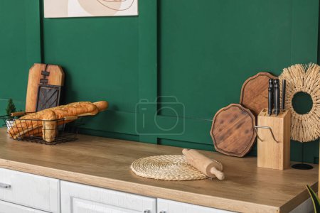 Téléchargez les photos : Baguettes dans le panier, planches à découper, rouleau à pâtisserie et ustensiles sur comptoir de cuisine en bois - en image libre de droit