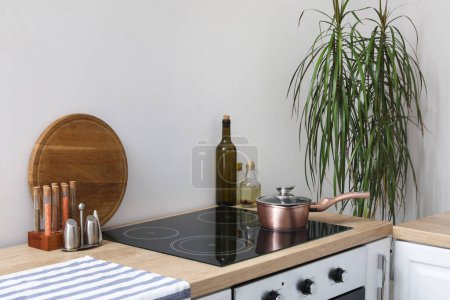Téléchargez les photos : Comptoir de cuisine avec planche à découper, cuisinière électrique, cuisinière et condiments - en image libre de droit