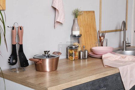 Téléchargez les photos : Comptoirs de cuisine avec planche à découper, évier, ustensiles et casserole - en image libre de droit