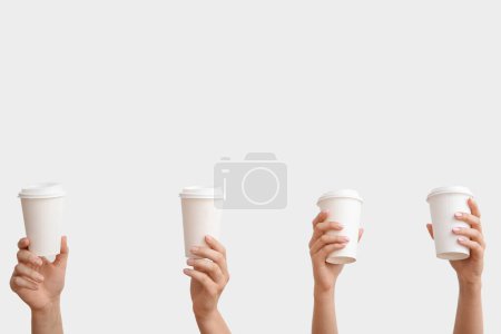Téléchargez les photos : Mains féminines avec des tasses en papier à emporter sur fond blanc - en image libre de droit
