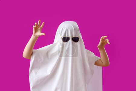 Téléchargez les photos : Petit garçon habillé pour Halloween comme fantôme sur fond violet - en image libre de droit
