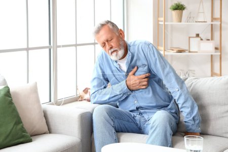 Photo for Mature man having heart attack at home - Royalty Free Image