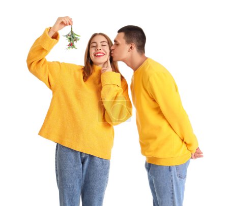 Téléchargez les photos : Jeune couple avec branche de gui sur fond blanc - en image libre de droit