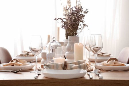 Foto de Elegante mesa con flores secas, velas encendidas y vasos - Imagen libre de derechos