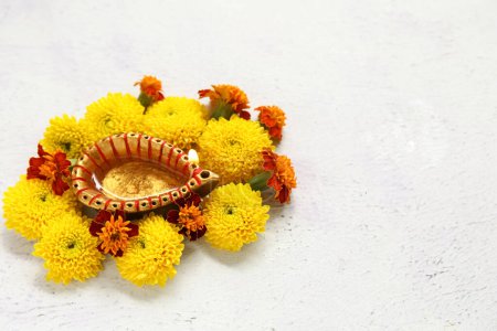 Photo for Diya lamp with beautiful marigold flowers on grunge white background. Divaly celebration - Royalty Free Image