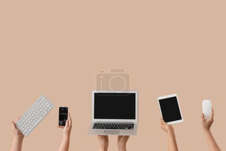 Téléchargez les photos : Femmes avec gadgets modernes sur fond beige - en image libre de droit