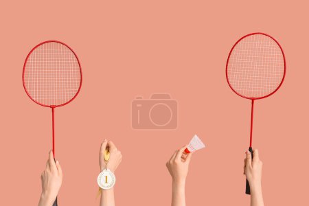 Photo for Female hands with badminton rackets, shuttlecock and medal on pink background - Royalty Free Image