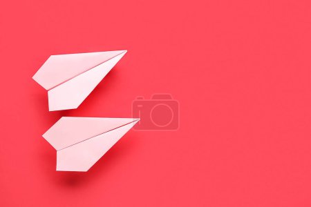 Foto de Planos de papel de origami rosa sobre fondo rojo - Imagen libre de derechos
