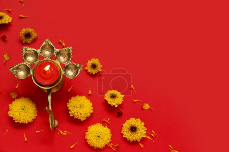 Photo for Diya lamp with beautiful flowers on red background. Divaly celebration - Royalty Free Image