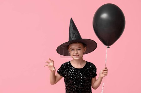 Téléchargez les photos : Petite fille mignonne habillée pour Halloween en sorcière avec ballon sur fond rose - en image libre de droit