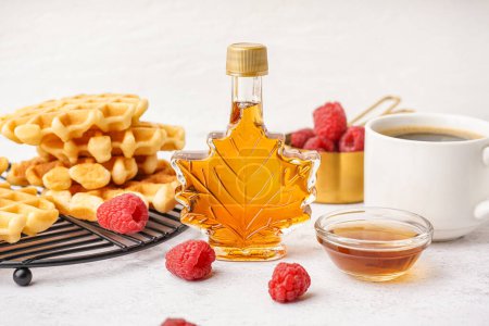 Photo for Bottle and bowl of sweet maple syrup with raspberries on white background - Royalty Free Image