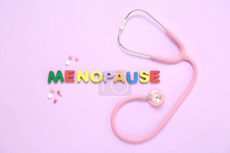 Word MENOPAUSE avec pilules et stéthoscope sur fond rose
