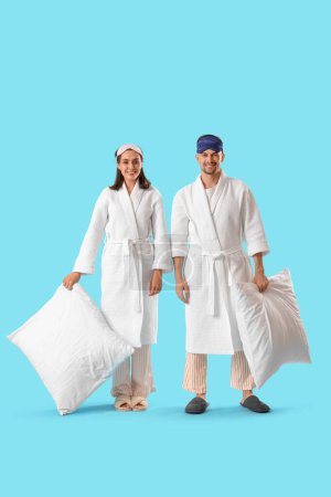 Photo for Young couple with soft pillows on blue background - Royalty Free Image