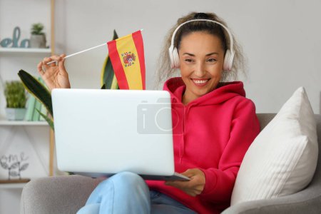 Photo for Mature woman with laptop studying Spanish online at home - Royalty Free Image