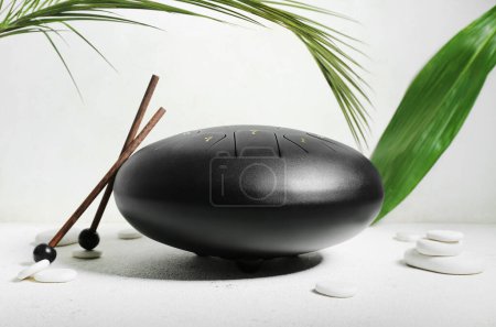 Glucophone with sticks, spa stones and palm leaves on grunge white background