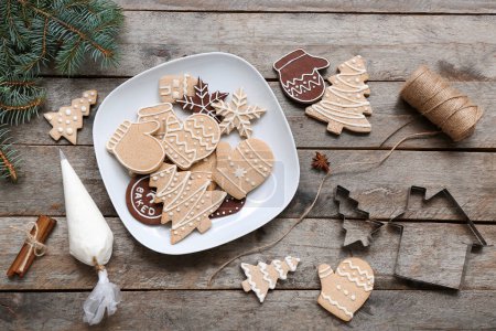 Foto de Composición con sabrosas galletas de Navidad, crema y cortadores sobre fondo de madera - Imagen libre de derechos