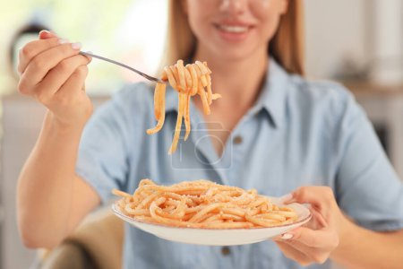 Téléchargez les photos : Jeune femme mangeant des pâtes savoureuses à la maison, gros plan - en image libre de droit