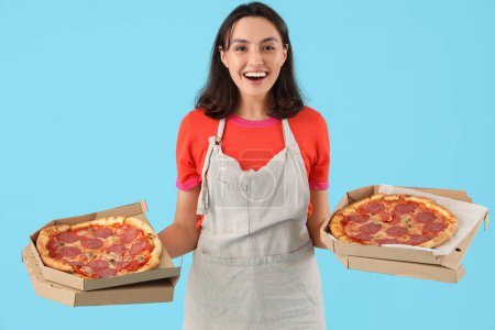 Photo for Young woman with tasty pepperoni pizza on blue background - Royalty Free Image