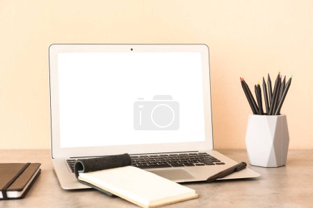 Foto de Portátil moderno, portátiles y portátiles con diferentes lápices en el escritorio - Imagen libre de derechos