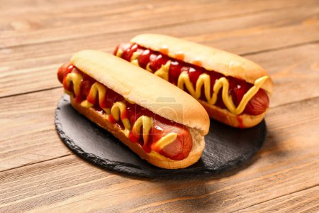 Plateau avec des hot-dogs savoureux sur fond en bois