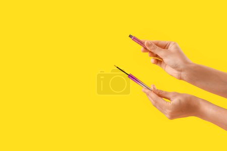 Téléchargez les photos : Femme avec eye-liner sur fond jaune - en image libre de droit