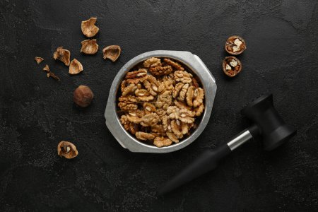 Photo for Metal bowl of tasty walnuts on black background - Royalty Free Image