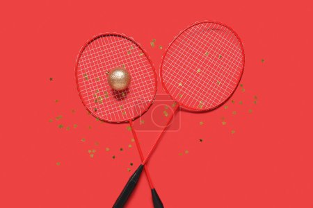Photo for Tennis rackets, Christmas ball and confetti on red background - Royalty Free Image