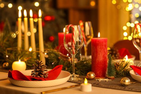 Foto de Ajuste de mesa de Navidad con velas encendidas en la habitación por la noche, primer plano - Imagen libre de derechos