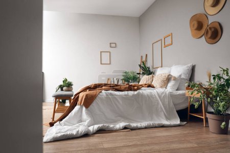 Téléchargez les photos : Intérieur de la chambre confortable avec lit confortable et banc gris, vue à travers le couloir - en image libre de droit
