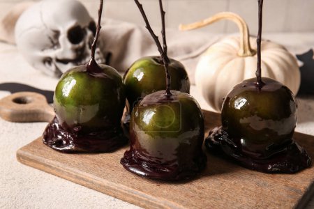 Photo for Wooden board of tasty caramel apples for Halloween on table - Royalty Free Image