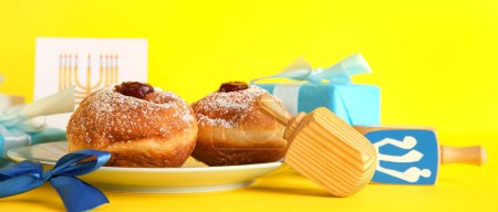 Photo for Tasty donuts, dreidels and gifts on yellow background. Hanukkah celebration - Royalty Free Image