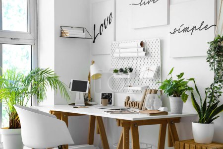 Photo for Interior of light office with workplace, pegboard and houseplants - Royalty Free Image