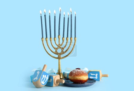 Photo for Menorah with gift boxes, dreidels and donut on blue background. Hanukkah celebration - Royalty Free Image