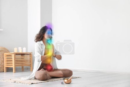 Téléchargez les photos : Jeune femme méditant et nettoyant chakras à la maison - en image libre de droit