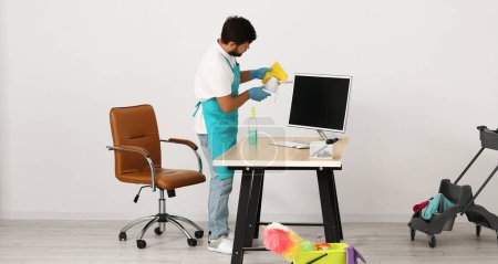 Photo for Male worker cleaning lamp in office - Royalty Free Image