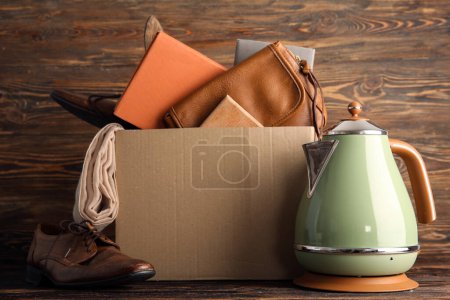 Foto de Caja de cosas no deseadas para la venta de garaje sobre fondo de madera marrón - Imagen libre de derechos