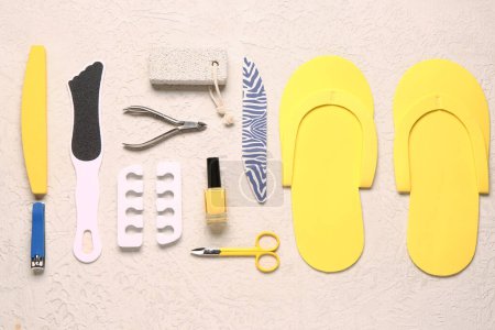 Foto de Set de herramientas profesionales para pedicura con esmalte de uñas sobre fondo blanco texturizado - Imagen libre de derechos