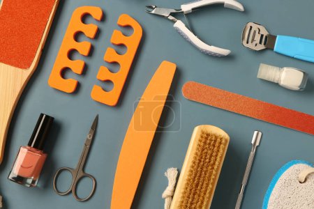 Foto de Set de herramientas profesionales para pedicura con esmaltes de uñas sobre fondo gris - Imagen libre de derechos