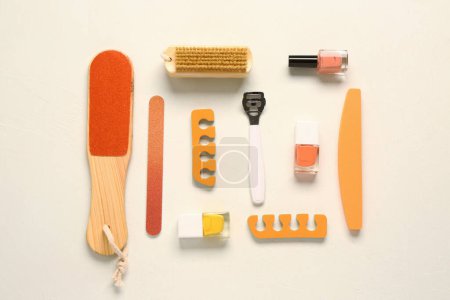 Foto de Set de herramientas profesionales para pedicura con esmaltes de uñas sobre fondo beige - Imagen libre de derechos
