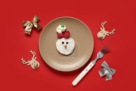 Photo for Plate with pancake in shape of snowman on red background. Christmas celebration - Royalty Free Image