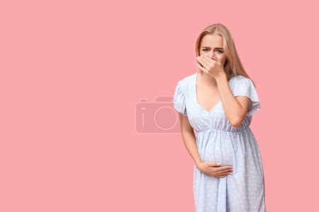 Téléchargez les photos : Belle jeune femme enceinte souffrant de toxicose sur fond rose - en image libre de droit