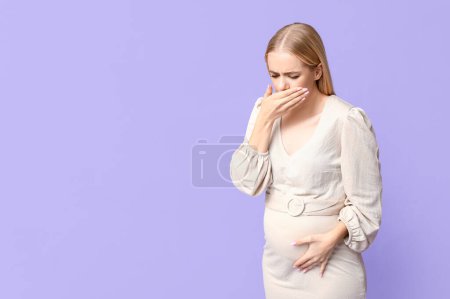 Téléchargez les photos : Belle jeune femme enceinte souffrant de toxicose sur fond lilas - en image libre de droit