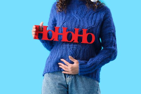 Téléchargez les photos : Femme enceinte avec salutation de Noël sur fond bleu, gros plan - en image libre de droit