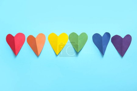 Corazones de papel de colores sobre fondo azul. Concepto LGBT