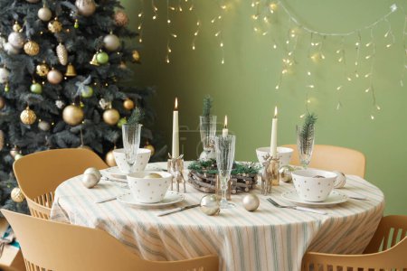 Photo for Festive table setting with Christmas decorations, reindeers and burning candles in dining room - Royalty Free Image