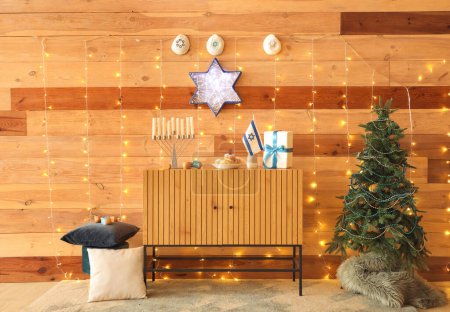 Photo for Interior of festive living room with wooden cabinet, glowing lights and traditional Hanukkah decorations - Royalty Free Image