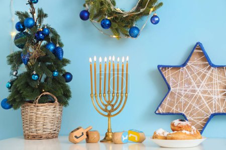 Photo for White table with fir tree and traditional Hanukkah decorations in living room - Royalty Free Image