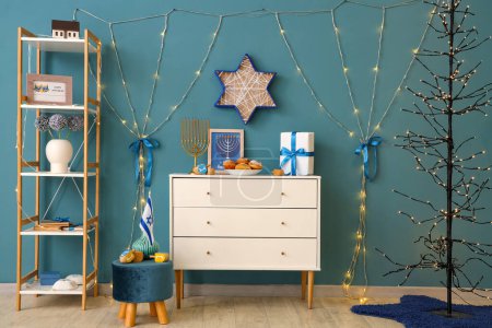 Photo for Interior of festive living room with chest of drawers, glowing lights and traditional Hanukkah decorations - Royalty Free Image