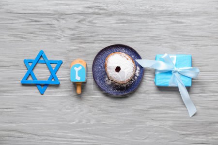 Photo for David star, dreidel, donut and gift box for for Hanukkah celebration on grey wooden background - Royalty Free Image